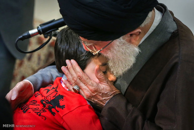 عکس: فرزند شهید مدافع حرم در آغوش رهبر انقلاب