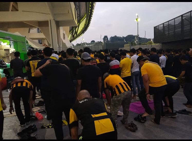 عکس/ نماز جماعت هواداران مالزیایی پیش از آغاز بازی